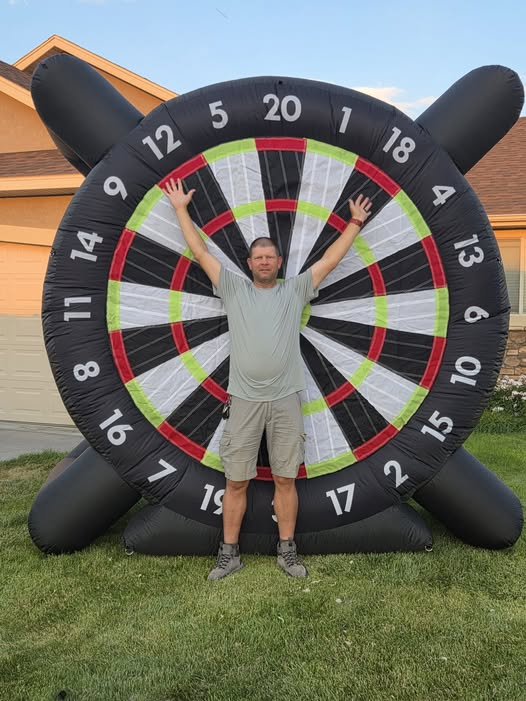 Jared standing in front of a giant inflatable soccer darts board on an Idaho lawn
